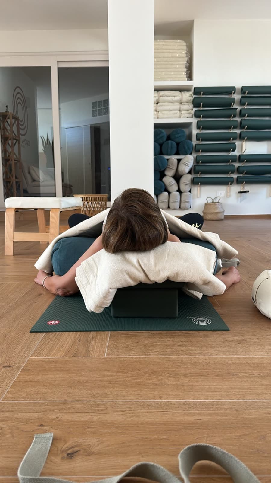 Un angolo della sala di MaMo: tappetini verdi, bolster e coperte